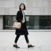 Woman in stylish capsule wardrobe outfit walking in a modern city