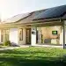 Modern energy-efficient home with solar panels and smart thermostat, symbolizing cost savings and sustainability.