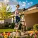 Person inspecting clean gutters on a house during spring, representing DIY home maintenance readiness.